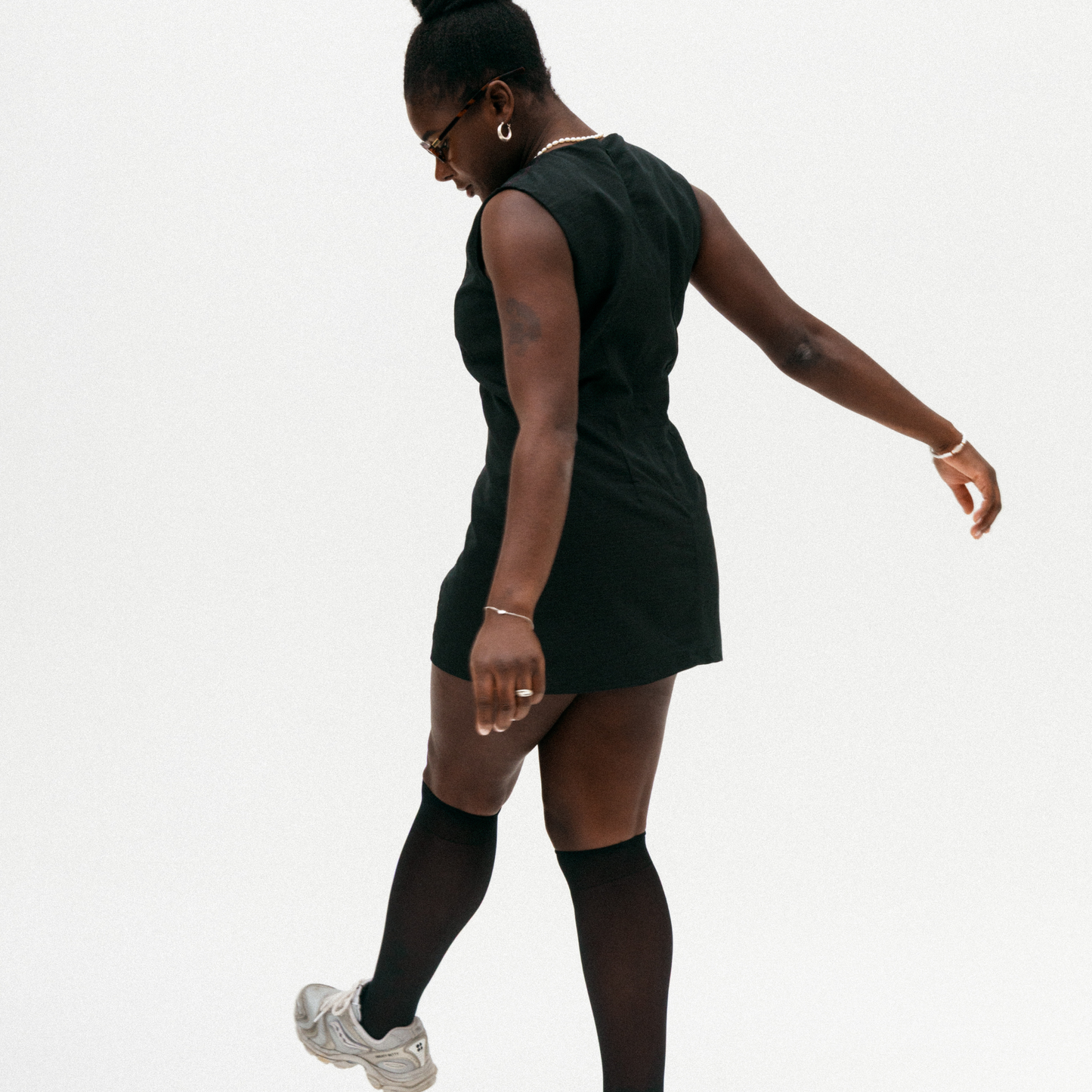 Person wearing a black sleeveless dress on a white background