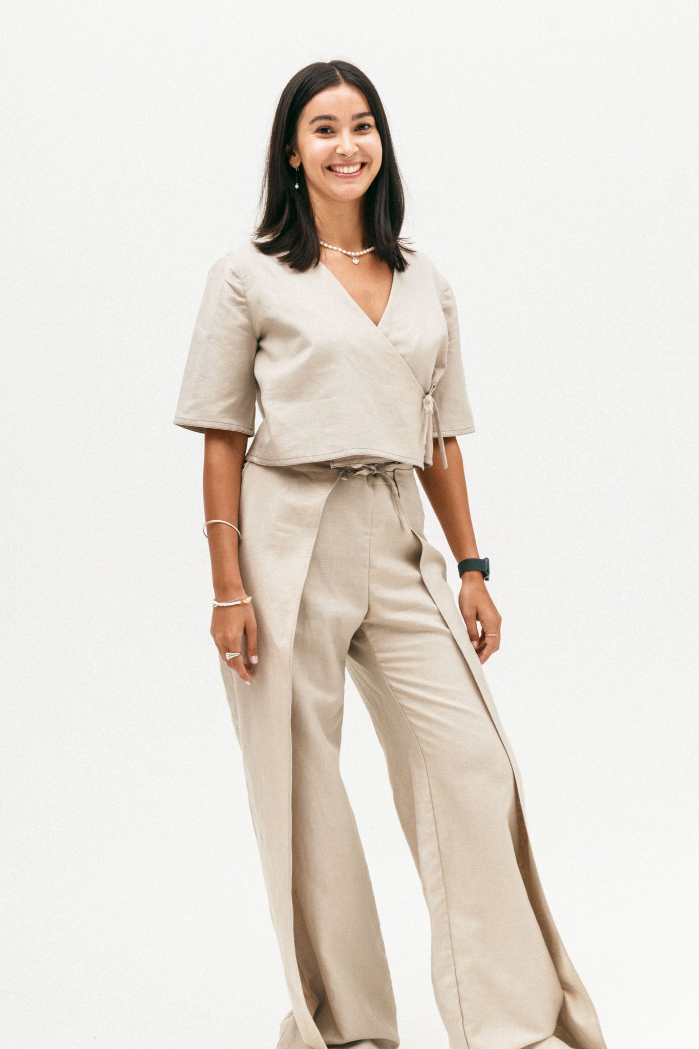 Woman wearing a beige outfit with a plain background