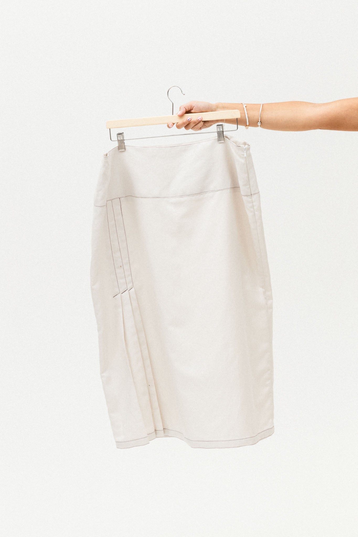 White skirt on a hanger against a white background