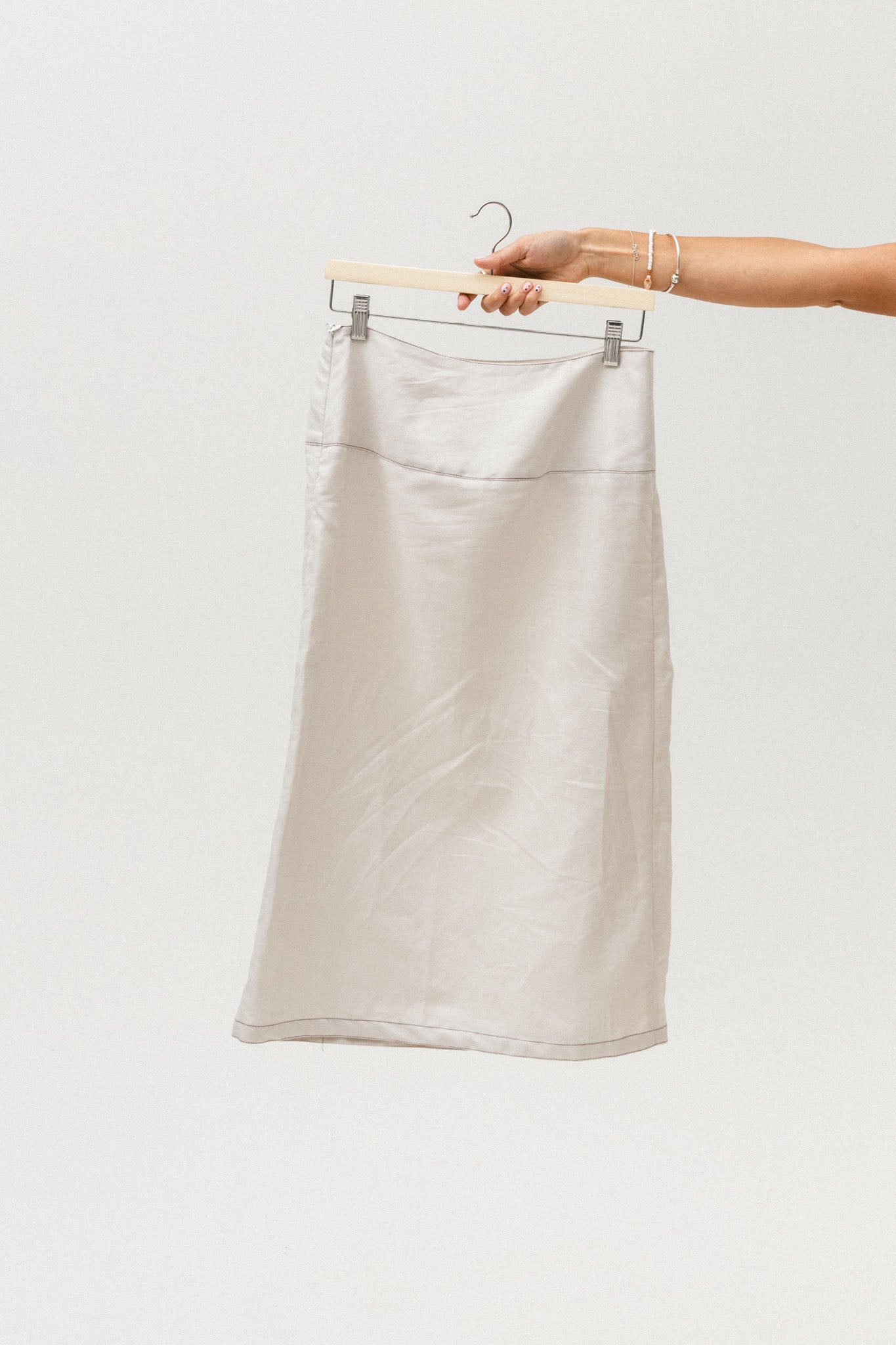 White skirt on a hanger against a white background